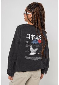 Černé tričko s dlouhým rukávem s grafickou potiskem hory Fuji, jeřába a japonského textu na zádech, s volným střihem a měkkou texturou.