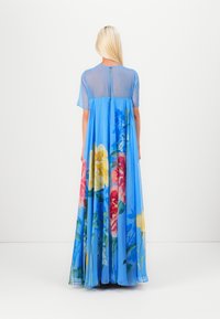 Light blue maxi dress with a sheer bodice and floral print in pink, yellow, and blue. Features short sleeves and a back button closure.