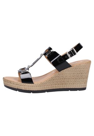 Sandale en wedge en vernis noir avec une semelle plateforme tressée couleur tan, des boucles en argent et une bride de cheville réglable.