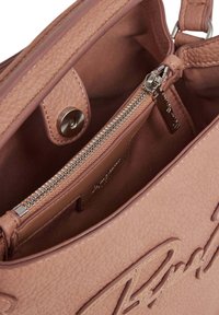 Roze nepleren handtas interieur met een ritsvak. Beschikt over een gestructureerde afwerking en een metalen drukknoopsluiting.