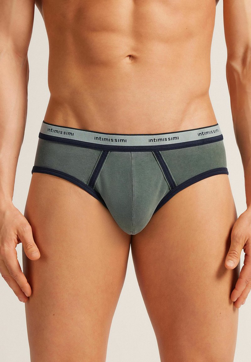 Herrenunterwäsche in einem gedämpften grünen Stoff mit navyfarbenen Akzenten. Verfügt über einen kontrastierenden Bund mit Markenlogo, körpernahen Schnitt und glatter Textur.