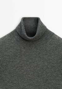 Pull à col roulé gris en tissu tricoté doux. Il présente un col montant et une texture côtelée, offrant chaleur et ajustement confortable.