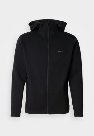 Czarna bluza rozpinana na zamek z gładkiego materiału, z kapturem, bocznymi kieszeniami na zamek oraz małym wytłaczanym logo na piersi.