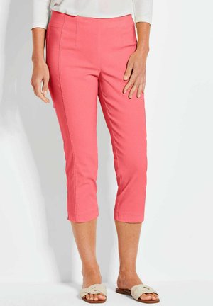 Pantaloni cropped rosa realizzati in un tessuto morbido, con vita aderente e tasche inclinate, abbinati a sandali leggeri.