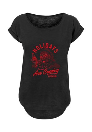Schwarzes T-Shirt mit kurzen Ärmeln, das ein rotes Grafikmotiv von Santa zeigt, der eine Coke-Flasche hält, mit dem Text "DIE FEIERTAGE KOMMEN" in Rot.