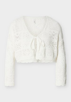 Valkoinen virkattu lyhyt neuletakki, jossa pitkät hihat ja etupuolella solmittava nauha, koristeltu erilaisilla avokuvioilla ja tekstuureilla.