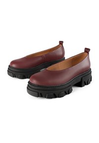 Burgundy leather shoes with a rounded toe and a thick black platform sole featuring a textured design and pull tab at the heel.