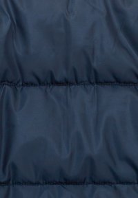 Námorněmodrá prošívaná bunda vyrobená z látky s hladkým lesklým povrchem, s horizontálně prošívanými liniemi, které vytvářejí prošívané sekce.