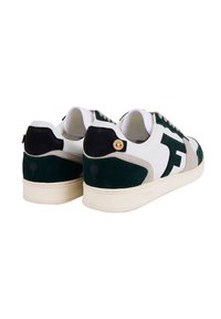 Une paire de baskets blanches avec du daim vert foncé et beige, des patchs arrière noirs avec des boutons en bois, et des semelles blanches.