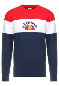 Svetr s designem červených a bílých bloků a námořnický modrý spodní díl; obsahuje vyšívané logo s oranžovými a červenými akcenty; bavlněný materiál.