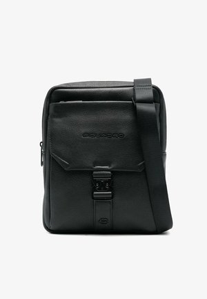 Sac bandoulière en cuir noir avec poche avant à rabat, fermeture à boucle métallique, bandoulière ajustable et logo de marque embossé à l'avant.