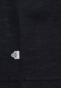 Schwarzer Stoff mit einer strukturierten Musterung zeigt ein kleines weißes Logo-Tag in der unteren Ecke, das ein elegantes Design und genähtes Detail präsentiert.