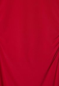 Gladko rdeče blago z rahlimi gubami, ki kaže mehko teksturo in žive barve.