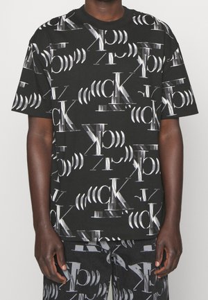 Schwarzes Kurzarm-T-Shirt mit einem wiederholten weißen Logo-Muster. Aus Baumwolle gefertigt und mit einem lockeren Schnitt, zeigt einen runden Halsausschnitt.