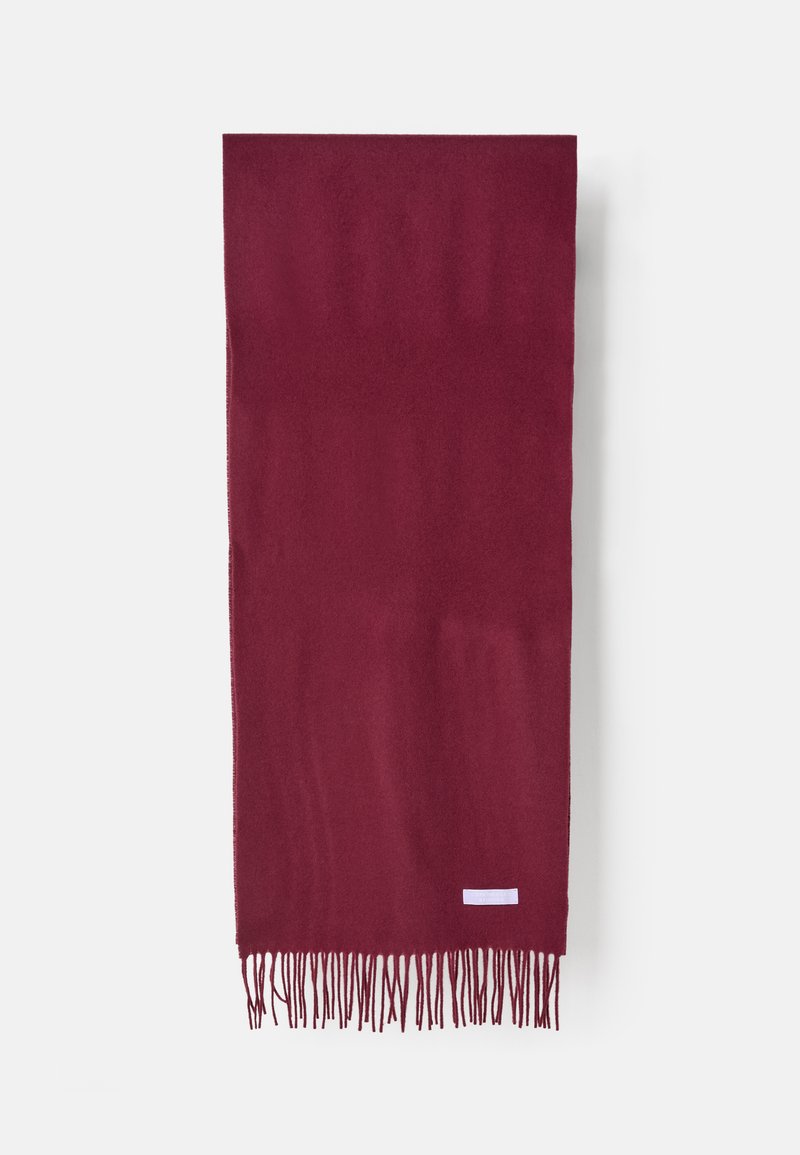 Bufanda burdeos hecha de una tela suave, con largos flecos en un extremo y una pequeña etiqueta blanca cerca de la parte inferior. Textura suave, forma rectangular.