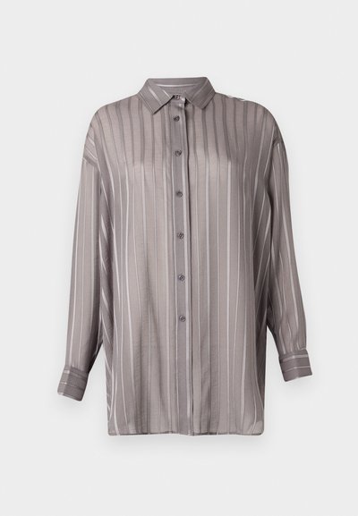 Camicia grigia chiara con righe verticali, maniche lunghe e colletto. Realizzata in un tessuto liscio e leggermente trasparente.