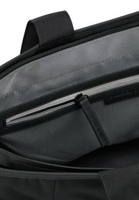 Borsa di tessuto nera con interno grigio, dotata di tasca con zip e etichetta del marchio. Design semplice incentrato sulla funzionalità e sull'organizzazione.