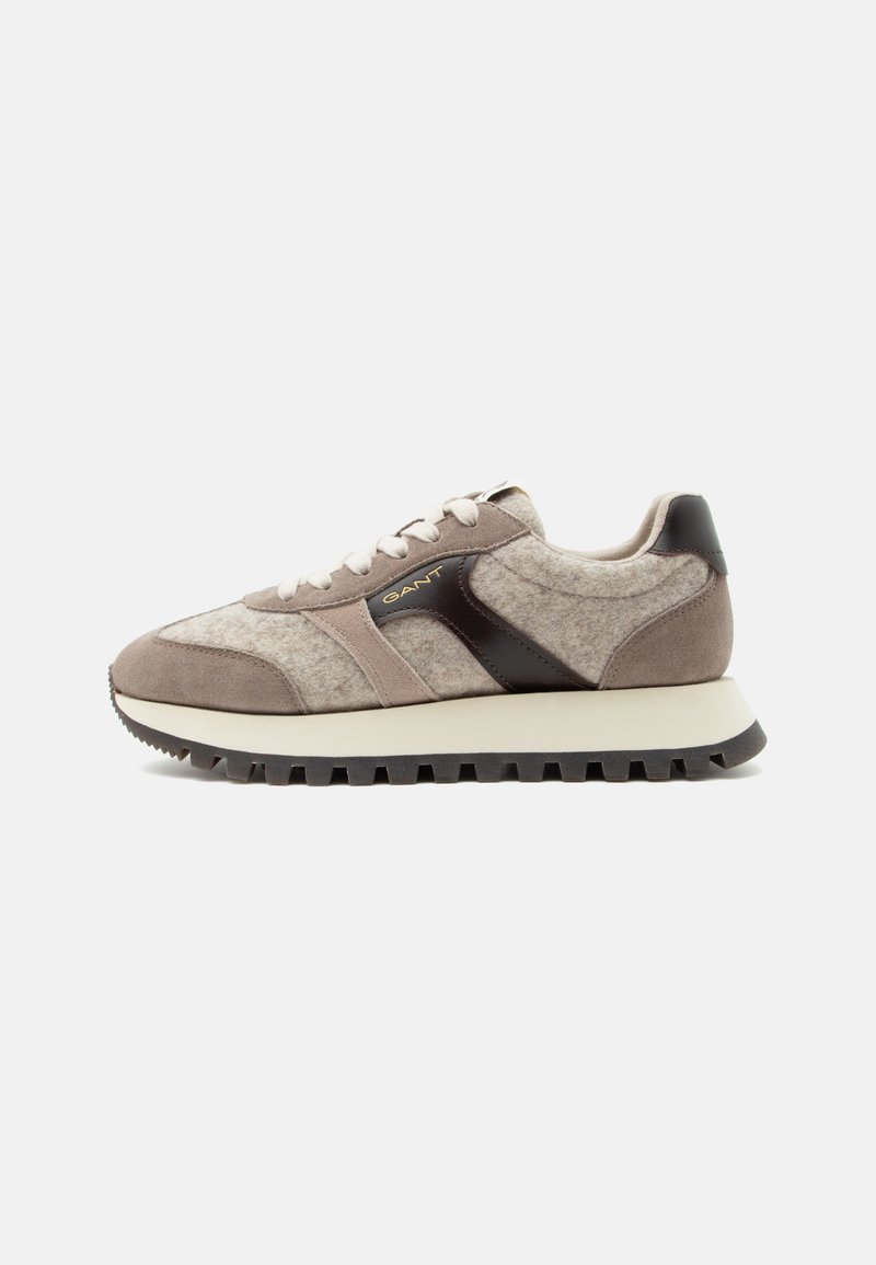 Baskets décontractées beige et taupe avec détails latéraux noirs, lacets blancs, semelle texturée et logo GANT sur le panneau latéral.
