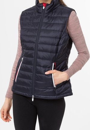 Marineblå polstret vest med høj krave, frontlynlås og to sidelommer, med kontrasterende hvide lynlåse og røde detaljer. Glat tekstur.