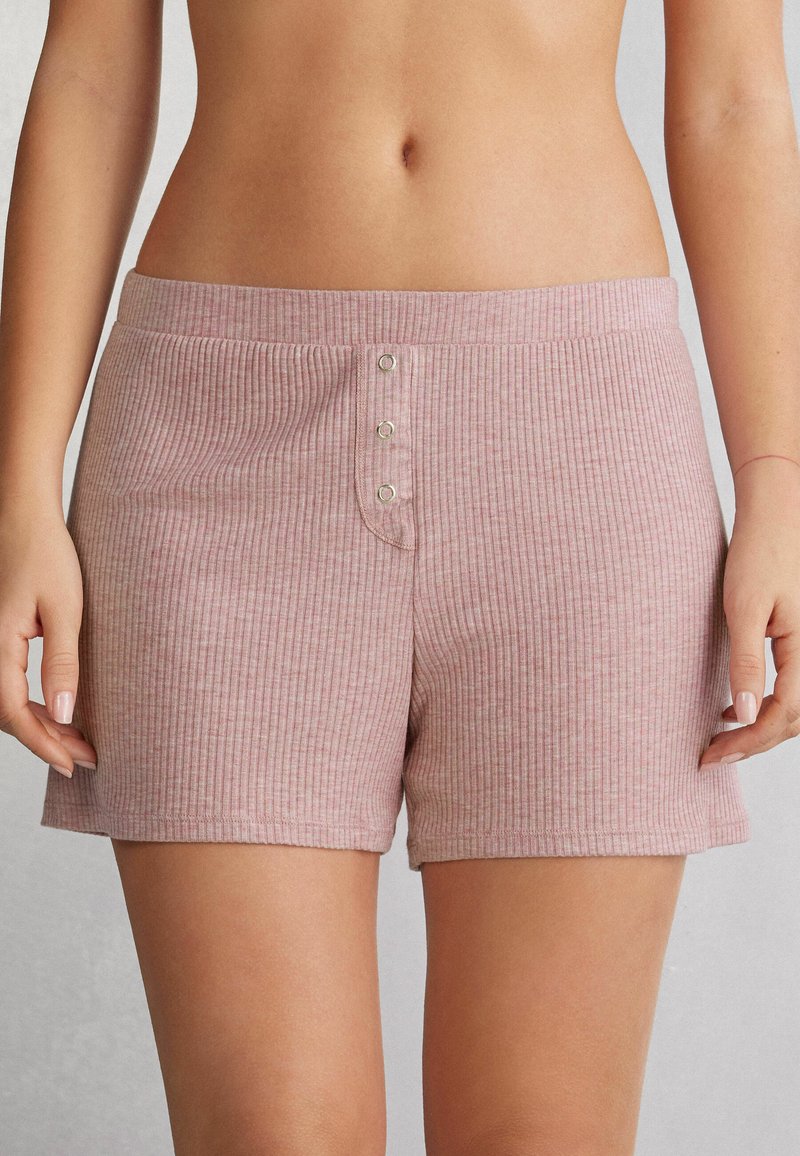 Svetle růžové ribbované šortky s jemnou texturou, mají pas a tři kovové knoflíky vpředu. Ležérní design s kapsami.