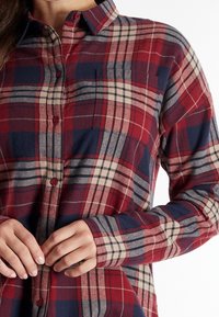Rood, marineblauw en beige geruit flanellen shirt met een knoopsluiting aan de voorkant, kraag en borstzak. Zachte textuur met lange mouwen.
