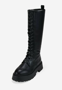 Botas de cuero negras hasta la rodilla, con cordones, que presentan una suela de plataforma gruesa y un cordaje texturizado a lo largo del costado para un detalle adicional.