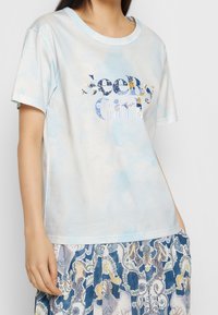 Ljusblå bomulls t-shirt med "See By Girl" grafik i olika mönster. Avslappnad passform med korta ärmar och rund halsringning.
