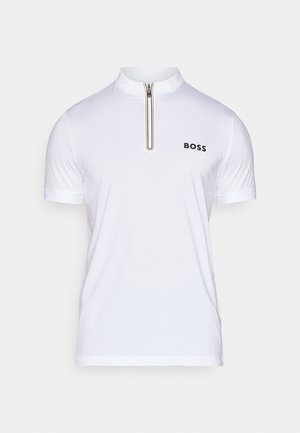 Camisa polo blanca de manga corta con collar alto, media cremallera y un logo negro. Cuenta con una tela texturizada para una mejor transpirabilidad.