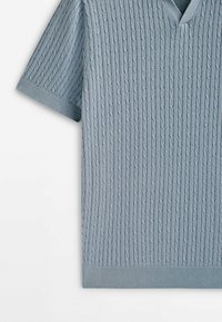 Pull-over à col en V à manches courtes de couleur bleu clair, texturé avec un motif de câble côtelé, doté d'une finition lisse sur l'ourlet et les poignets.