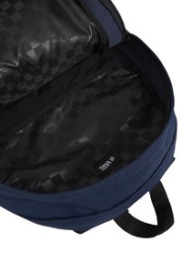 Blå ryggsäck med en strukturerad tygutsida. Inuti finns ett svart rutig foder och en nätficka på ena sidan.