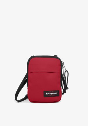 Röd tygaxelväska med zippered topp, framficka, svart trim, justerbar rem och en Eastpak-logotyp på framsidan.