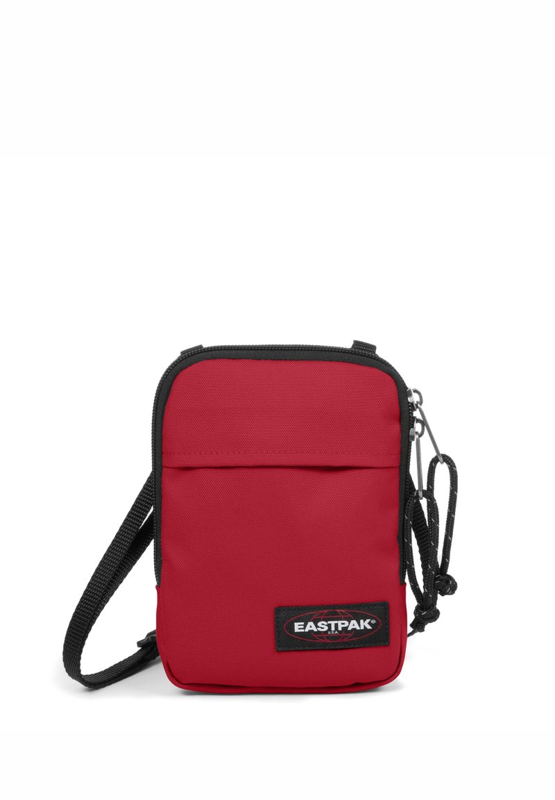 Borsa a tracolla rossa in tessuto con zip superiore, tasca frontale, bordo nero, tracolla regolabile e patch del logo Eastpak sulla parte frontale.