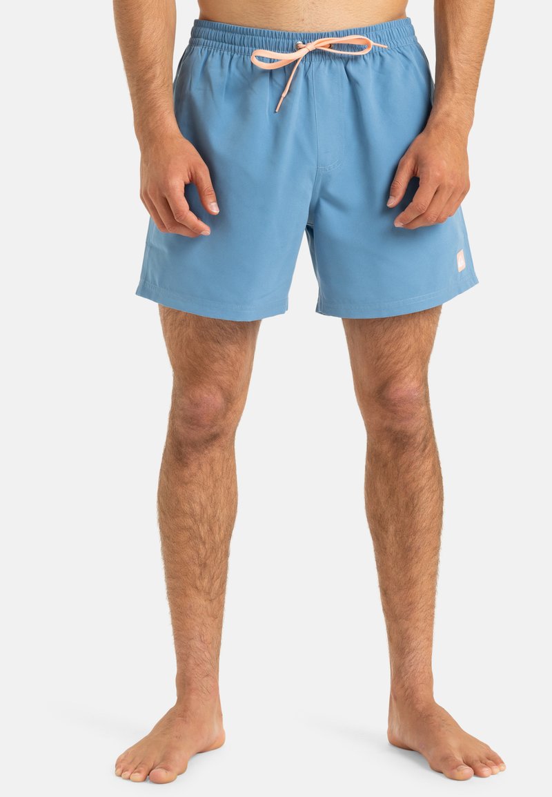 Light blue swim shorts with an elastic waistband, pink drawstring, and a small white logo patch on the side. Smooth, durable fabric.