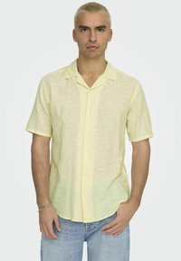 Korte mouwen gele linnen shirt met een kraaglijn en knoopsluiting, met een subtiele textuur en twee voorzakken.