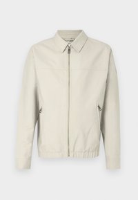 Šviesiai pilkas bomber tipo džemperis su užtrauktuku, taškiniu apykakle, dviem šoninėmis kišenėmis ir elastingomis rankovėmis. Lygus audinys su paprastu, minimalistiniu dizainu.