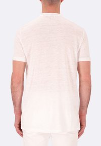 T-shirt bianco a maniche corte realizzato in un tessuto leggero e dalla texture speciale. Presenta un collo a giro e una vestibilità morbida, con un orlo posteriore leggermente più lungo.