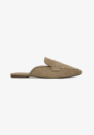 Beige Veloursleder-Loafer ohne Fersenteil mit flacher Sohle und dekorativem Riemen über dem Spann.