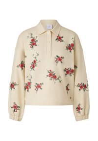 Beżowy sweter z kołnierzem, ozdobiony czerwoną, kwiatową haftowaną dekoracją na przodzie. Ma luźny krój i elastyczne ściągacze na rękawach.