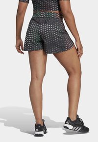 Svarta atletiska shorts med ett geometriskt mönster i grönt, rött och vitt. Elastisk midjerem och en avslappnad passform för komfort.