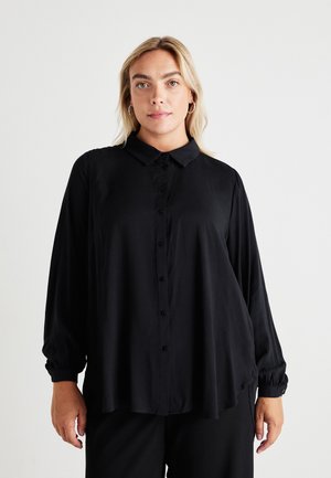Black button-up blouse made from smooth fabric, featuring a classic collar, long puffed sleeves, and a relaxed, oversized fit.