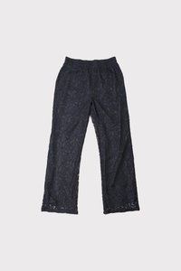 Fekete csipkeborítású nadrág, virágmintával, rugalmas derékkal, laza szabású, enyhén harang alakú szárakkal, fodros szegéllyel.