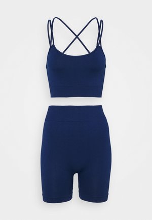 Ensemble de sport deux pièces bleu marine sans couture avec un débardeur court à fines bretelles et un short cycliste moulant taille haute.