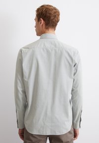 Langärmliges Hemd in hellgrün mit dezentem Muster, ausgestattet mit einem Button-Down-Kragen und geradem Saum; glattes Material mit lässiger Passform.