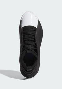 Scarpa sportiva nera con tomaia testurizzata, puntale bianco lucido e lacci neri. Presenta una forma arrotondata e una linguetta imbottita.