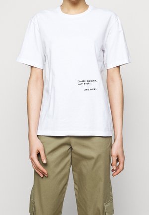 T-shirt en coton blanc à manches courtes. Présente une impression de texte en noir, indiquant "FERMÉ POUR TOUJOURS ET À JAMAIS... ET À JAMAIS."
