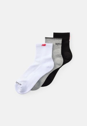Trois paires de chaussettes de sport : blanches avec un logo rouge, grises avec des rayures noires et noires unies. Texture côtelée, hauteur mi-mollet.