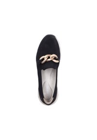 Scarpa slip-on nera in suede con dettagli in catena beige ampia, soletta imbottita e suola chiara. Texture liscia con forma arrotondata.