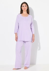 Conjunto de pijama lavanda que incluye una parte superior de manga larga con cuello redondeado, tapeta de botones decorativa y borde de encaje. Pantalones a juego con dobladillos de encaje.