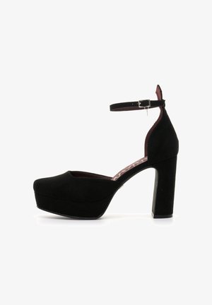 Tacchi a piattaforma in suede nero con punta arrotondata, cinturino alla caviglia e tacco alto chunky. Presentano una fodera interna in contrasto color marrone bordeaux.