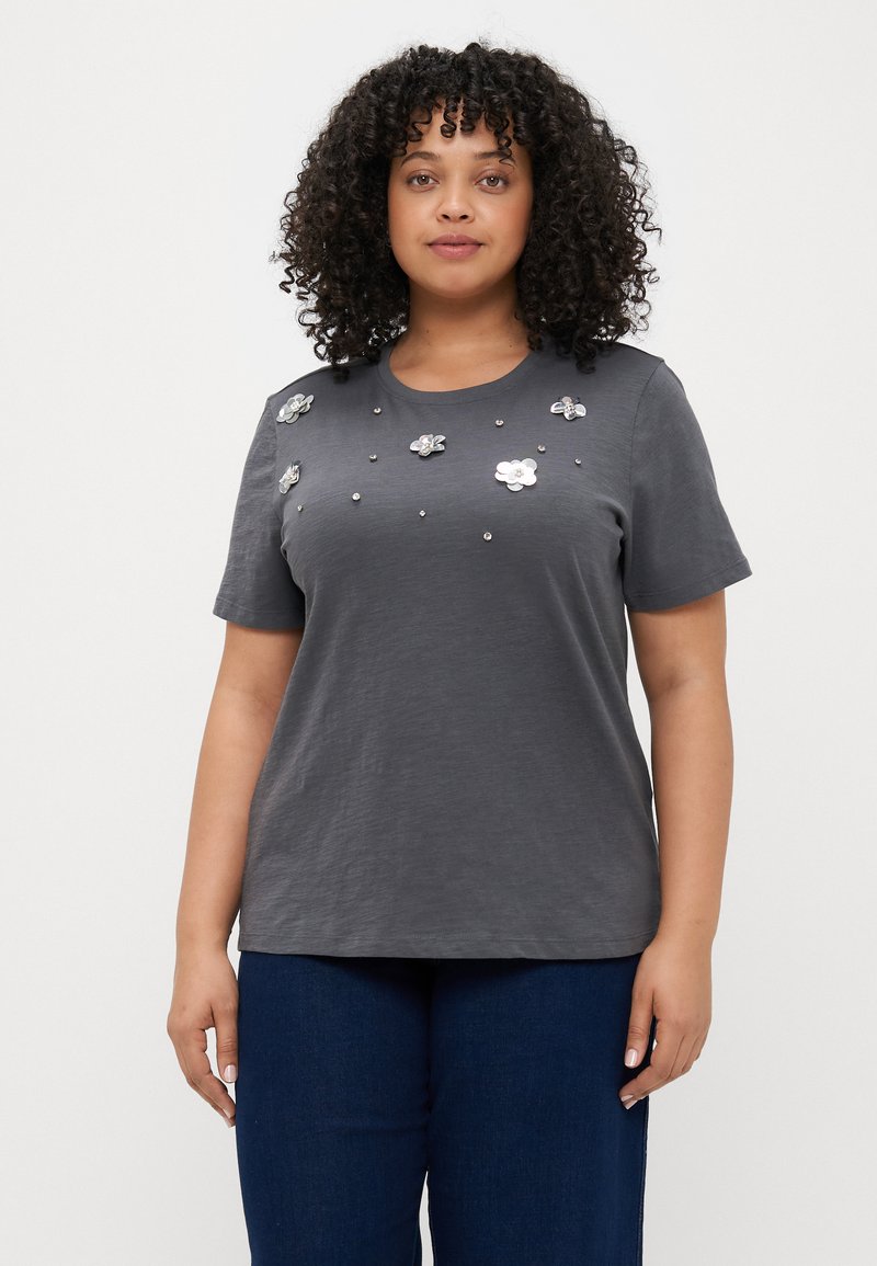 Grå T-skjorte med kort erme som har blomsterdekorasjoner og perlesmykker over fronten, laget av mykt stoff med en avslappet passform.